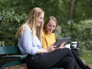 Zwei Studierende auf einer Parkbank