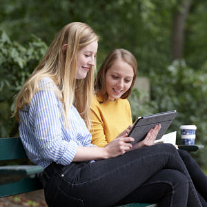 Zwei Studierende auf einer Parkbank
